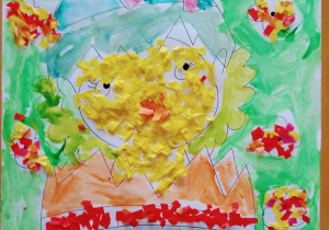 Obrazek kurczaka wykluwającego się z jajka pomalowany został przez młodsze dzieci farbami akwarelowymi oraz wyklejony drobnymi ścinkami papieru kolorowego.